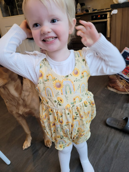 happy child wearing sinclair romper in a sunflower dessign