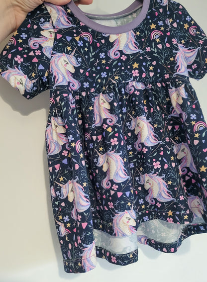Close-up of unicorn fabric showing sleeve and bodice detail on handmade children’s peplum top